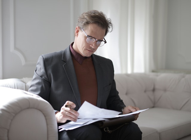 a person on a sofa reading papers